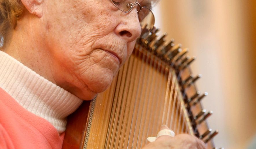 In this photo taken April 8, 2016, Verla Boyd closes her eyes as she strums her autoharp along with the Hoosier String Players, a folk and mountain music club, while they jam together in Kokomo, Ind. The group has been playing together for about 16 years. (Kelly Lafferty Gerber/The Kokomo Tribune via AP) MANDATORY CREDIT