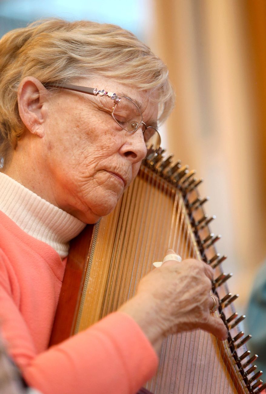 In this photo taken April 8, 2016, Verla Boyd closes her eyes as she strums her autoharp along with the Hoosier String Players, a folk and mountain music club, while they jam together in Kokomo, Ind. The group has been playing together for about 16 years. (Kelly Lafferty Gerber/The Kokomo Tribune via AP) MANDATORY CREDIT