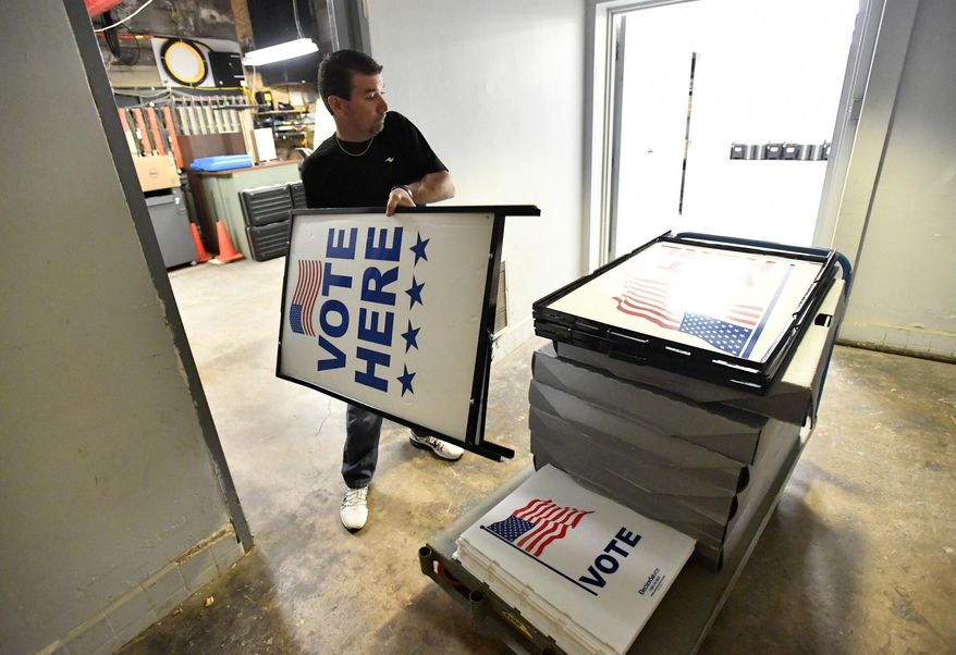 Dusty DeVinney places "vote here" signs onto a cart as he loads election materials at the Willowbank building Monday, April 25,2016, in Bellefonte, Pa., in preparation for Tuesday's primary election. For the first time in many years, Democrats and Republicans in Pennsylvania on Tuesday pick presidential candidates in a meaningful primary. A U.S. Senate primary will determine who represents the Democrats this fall in the race to unseat Sen. Pat Toomey, and voters from both parties choose their candidates for attorney general. (Nabil K. Mark/Centre Daily Times via AP) MANDATORY CREDIT; MAGS OUT