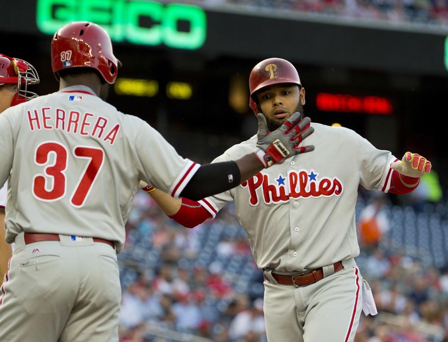 Philadelphia Phillies Andres Blanco is greeted at home by teammate Odubel Herrerra after hitting a two-run homer off Washington Nationals starting pitcher Max Scherzer (31) during the first inning of a baseball game, Tuesday, April 26, 2016 in Washington. (AP Photo/Pablo Martinez Monsivais)