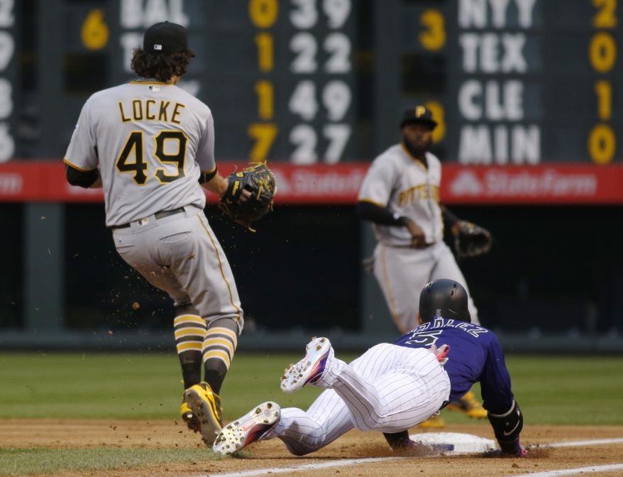 Colorado Rockies' Carlos Gonzalez, front right, dives safely into first base for an infield single as Pittsburgh Pirates starting pitcher Jeff Locke, front left, fields the throw from second baseman Josh Harrison in the first inning of a baseball game Monday, April 25, 2016, in Denver. (AP Photo/David Zalubowski)