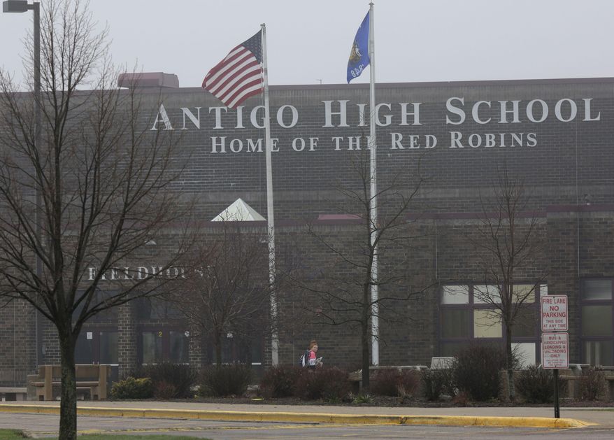 A student crosses below two flags while entering Antigo High School, Monday, April 25, 2016, in Antigo, Wis. According to police Jakob E. Wagner, 18, opened fire with a high-powered rifle outside of the a prom at Antigo High School late Saturday. (Jakob E. Wagner/The Marshfield News-Herald via AP) NO SALES; MANDATORY CREDIT