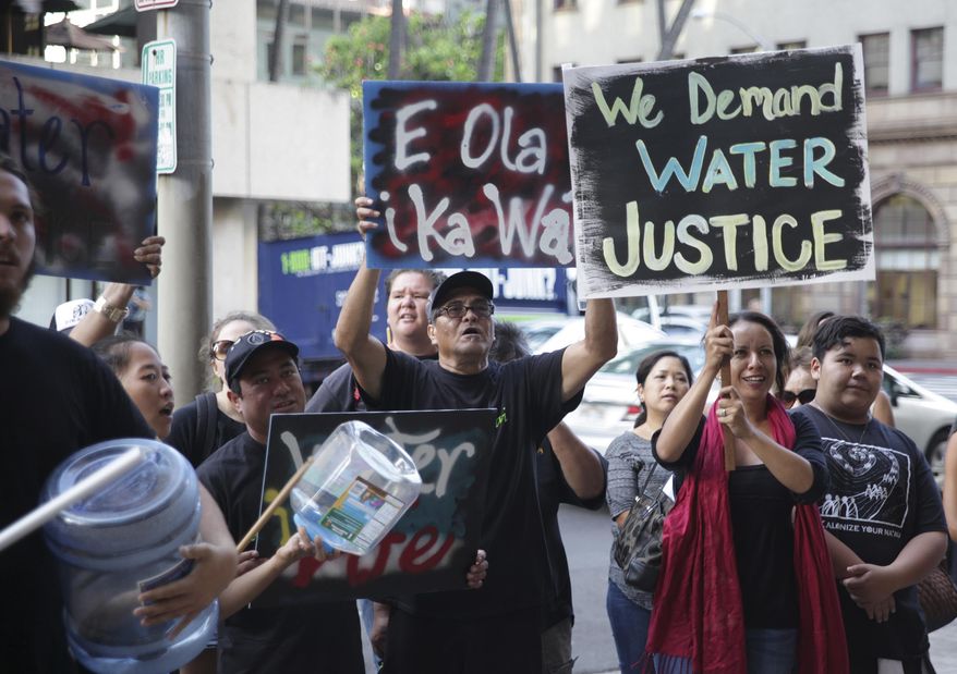 Protesters against a bill to allow companies and other water-rights holders to continue diverting water from Maui streams hold a rally outside of the Alexander & Baldwin Building in Honolulu, Tuesday, April 26, 2016. With Alexander & Baldwin scheduled to stop sugar operations at the end of the year, opponents say the company is just trying to hold onto water rights while it sucks the island dry of a public resource that many hope will be used to restore dry stream beds and farming communities. (AP Photo/Marina Riker)