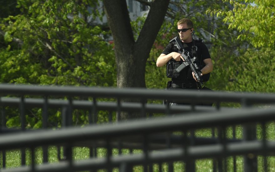 A uniformed Secret Service agent patrols the North Lawn of the White House in Washington, Tuesday, April 26, 2016. A man fleeing a robbery jumped a fence at the White House complex and was arrested, the Secret Service said, triggering a brief lockdown at the presidential residence. Secret Service officers arrested the man after he jumped the fence alongside the Eisenhower Executive Office Building, which is part of the White House complex.(AP Photo/Susan Walsh)