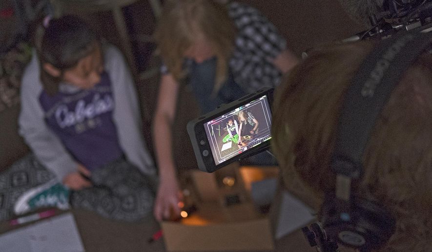 ADVANCE FOR THE WEEKEND OF APRIL 30-MAY 1 AND THEREAFTER - In a Wednesday, April 20, 2016 photo, a PBS camera operator films a pair of Jami Howe’s fourth-grade students as they work on a science exercise at Paintbrush Elementary School in Gillettte, Wyo. Campbell County's science program has garnered nationwide media attention which brought John Tulenko of "Education Week/PBS New Hour" to the school with a film crew to document a hands-on science project. (Ed Glazar/Gillette News Record via AP) TV OUT; MANDATORY CREDIT