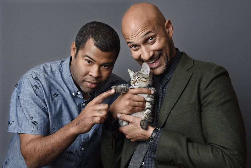 In this April 23, 2016 photo, Jordan Peele, left, and Keegan-Michael Kay hold a ten-week-old tabby as they pose for a portrait to promote their film, "Keanu," at The Beverly Hilton Hotel in Beverly Hills, Calif. (Photo by Chris Pizzello/Invision/AP)