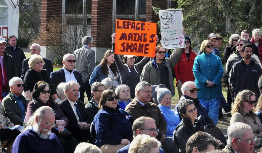 University of Maine in Farmington students Allyson Hammond, center left, and Nickolas Bray hold up anti-LePage posters during the dedication with feature speaker Maine Gov. Paul LePage for the Theodora Kalikow Education Center in Farmington, Maine, Tuesday, April 26, 2016. Republican Gov. LePage cut short an address at the university after being confronted by the two students holding signs critical of him and called the students "idiots." (David Leaming/The Central Maine Morning Sentinel via AP) MANDATORY CREDIT