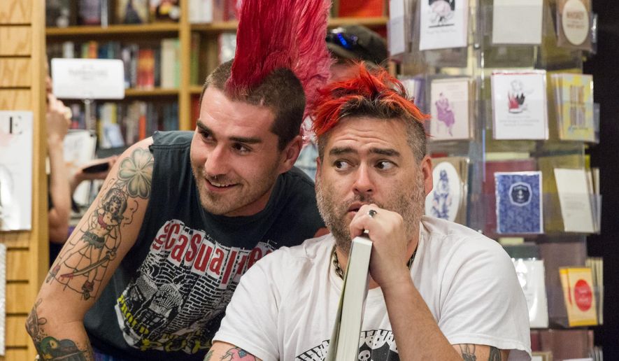 NOFX singer “Fat Mike” Burkett, right, poses with a fan at a book signing in Nashville, Tenn., on Tuesday, April 26, 2016. The punk band is exchanging grimy music venues for highbrow bookstores while promoting their joint autobiography “NOFX: The Hepatitis Bathtub and Other Stories.” (AP Photo/Erik Schelzig)
