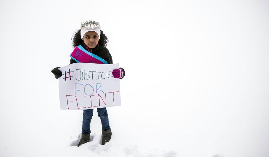 In a March 6, 2016 photo, Mari Copeny, 8, of Flint, Mich., stands with a protest sign during a #Justice4Flint rally at Wilson Park on University of Michigan-Flint's campus in Flint, Mich. The White House announced Obama's first visit to Flint Wednesday, April 27, 2016, by posting online a letter the president wrote to Amariyanna "Mari" Copeny. The 8-year-old activist known as "Little Miss Flint" wrote to the president to tell him she was coming to Washington to push lawmakers to do more for the city. (Jake May/The Flint Journal-MLive.com via AP)