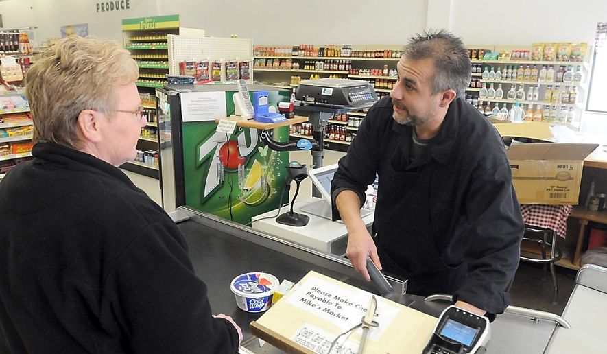 FOR RELEASE MONDAY, MAY 2, 2016, AT 12:01 A.M. CDT. - Mike's Market owner Mike Wegner helps a customer in the downtown Comfrey store. Wegner purchased the store in February after it was managed by the city for about a year. (Pat Christman/The Free Press via AP)