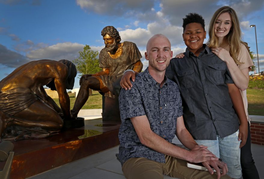 Chase Sims, left, poses for a photograph with his wife Corrinn Sims, right, and the boy they are helping raise, who would not give his name, at Prestonwood Baptist Church in Plano, Texas, Wednesday, April 20, 2016. Sims is batting a brain tumor while embracing each day. (Jae S. Lee/The Dallas Morning News via AP) MANDATORY CREDIT; MAGS OUT; TV OUT; INTERNET USE BY AP MEMBERS ONLY; NO SALES