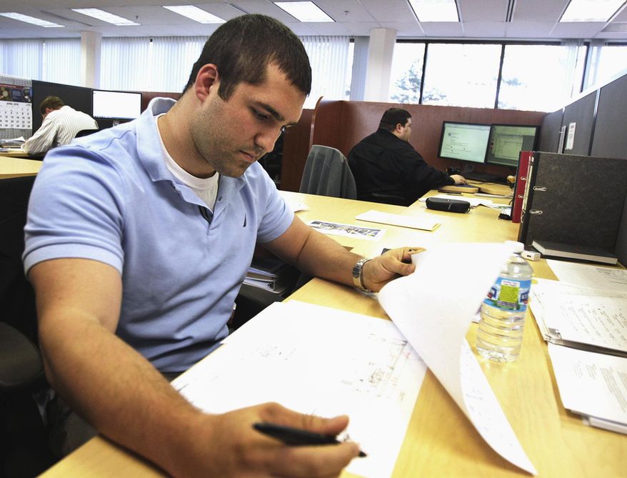 In this April 5,2016 photo, Eisenmann Corp. project manager Joe Schlesinger checks a schematic drawing at the company's headquarters in Crystal Lake, Ill. For some companies that employ a large segment of millennials in McHenry County, they've found that a clearly marked career path, engagement and perks providing the work-life balance many millennial workers are known to desire all can draw them to suburban locations and keep them there. (H. Rick Bamman/Northwest Herald via AP) CHICAGO TRIBUNE OUT, MANDATORY CREDIT