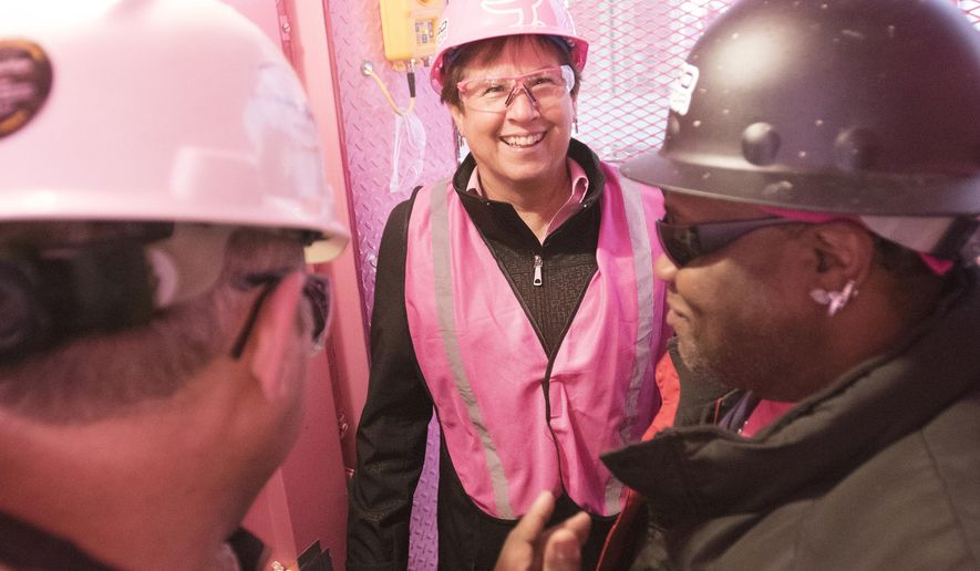 In this April 27, 2016 photo, Michigan first lady Sue Snyder takes the controls of the pink elevator during the “Ride the Pink Elevator” breast cancer awareness initiative in Detroit. Snyder has christened a campaign involving a pink elevator in Detroit to raise funds benefiting the Susan G. Komen organization for breast cancer research. (Daniel Mears/Detroit News via AP) DETROIT FREE PRESS OUT; HUFFINGTON POST OUT; MANDATORY CREDIT