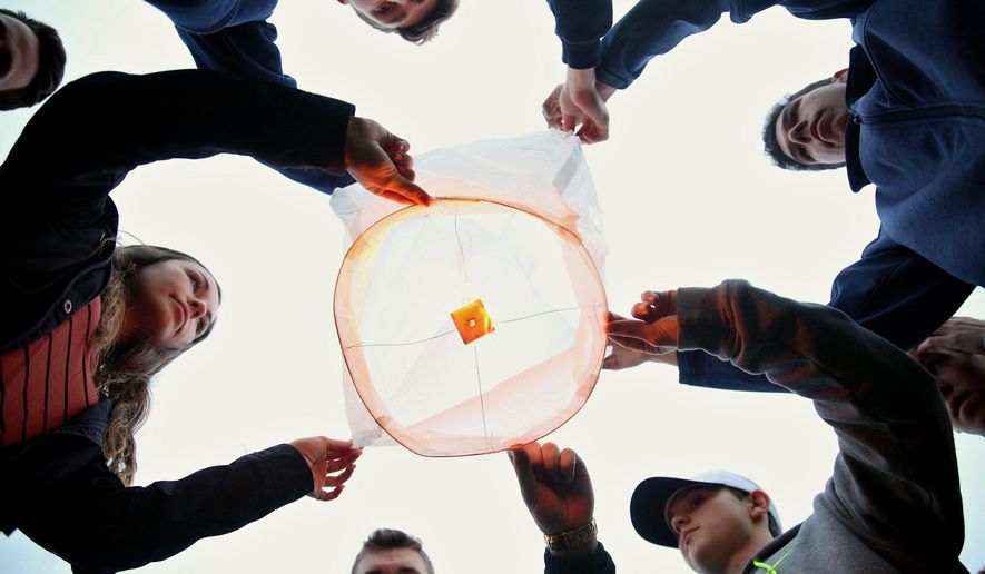 Friends and family of Tyler and Richard Smith prepare to release a lantern in their memory at Mattawan High School in Mattawan, Mich. on Wednesday, April 27, 2016. A tree has been dedicated in memory of Richard Smith and his 17-year-old son, Tyler, two of the victims of February mass shootings in southwestern Michigan. Uber driver Jason Dalton is charged in the apparently random Kalamazoo-area attacks that killed six. (Chelsea Purgahn/Kalamazoo Gazette-MLive Media Group via AP) LOCAL TELEVISION OUT; LOCAL RADIO OUT; MANDATORY CREDIT