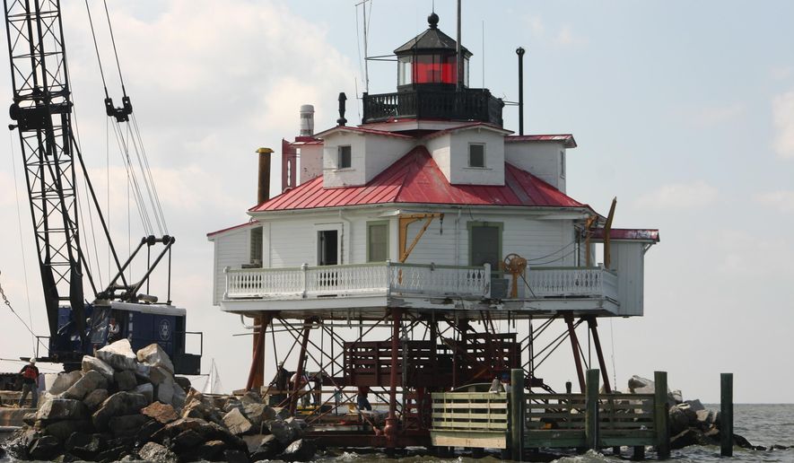 FILE - In this June 6, 2007 file photo, a barge works alongside the Thomas Point Shoal Lighthouse near Annapolis, Md., as part of a renovation project on the structure. Authorities are investigating a break-in and vandalism at the historic lighthouse in Maryland. Maryland Natural Resources Police say the lighthouse was targeted between April 15 and April 16, 2016. (AP Photo/Brian Witte)