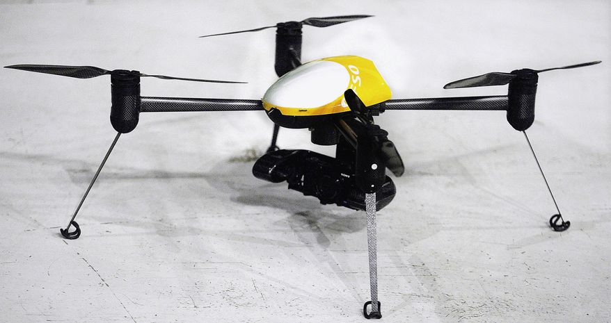 This June 24, 2014 file photo, shows a Draganflyer X4-ES drone, a professional, GPS guided, four-rotor UAV helicopter capable of autonomous flight, video and digital still images, during a demonstration in Grand Forks, N.D. (AP Photo/Bruce Crummy, File) **FILE**
