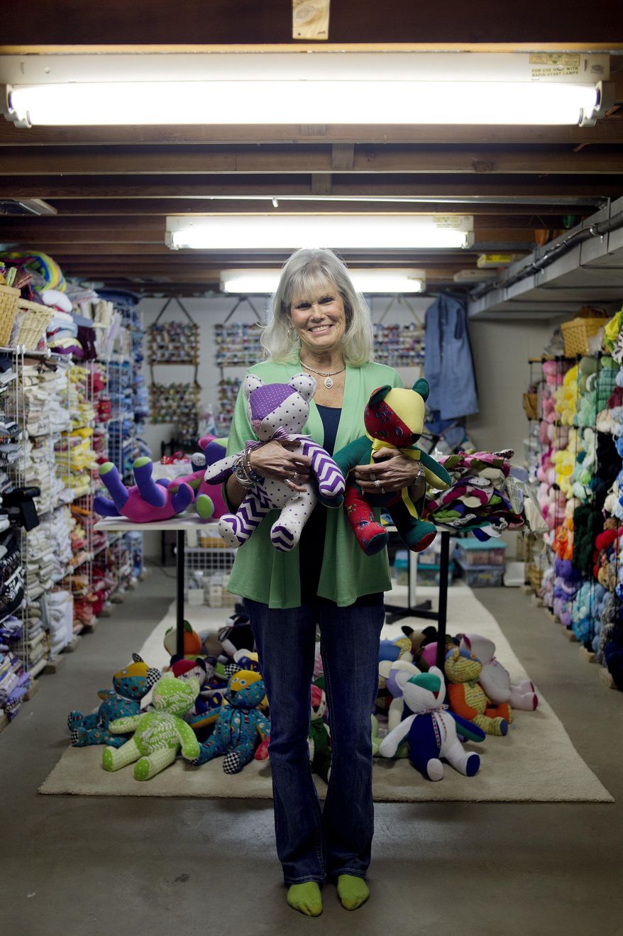 ADVANCE FOR WEEKEND EDITIONS -APRIL 30-MAY 2 - In this April 6, 2016, Jacqueline Lamont of Midland, Mich., poses for a portrait with two stuffed bears that she made in her sewing room. Lamont has sewn more than 500 bears that she gives away to law enforcement, hospitals and other agencies. Lamont's bears have brought comfort to children at MidMichigan Medical Center-Midland, Shelterhouse, children who encounter law enforcement and the St. Joseph Health System in Tawas. (Brittney Lohmiller/Midland Daily News via AP)MANDATORY CREDIT