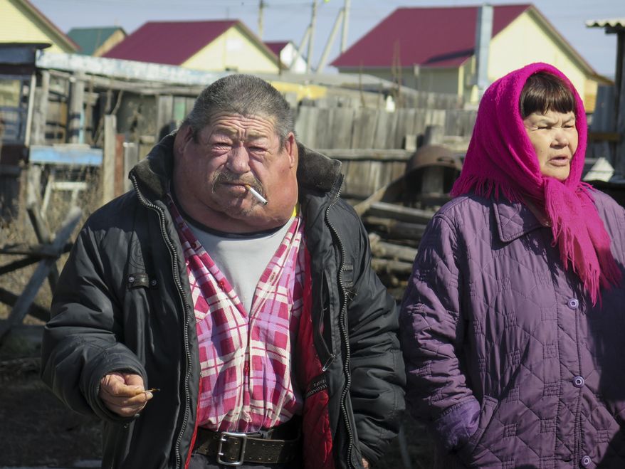 In this photo taken on Thursday, April 7, 2016, Vakil Batirshin and his wife Minfiza stand in their fenced side yard in the village of New Muslyumovo, Chelyabinsk region, Russia. Batirshin has swollen lymph nodes from radiation-related illnesses. Mayak, is a nuclear complex that has been responsible for at least two of the country’s biggest radioactive accidents. Worse, environmentalists say, is the facility’s decades-old record of using the Arctic-bound waters of the Techa River to dump waste from reprocessing spent nuclear fuel, hundreds of tons of which is imported annually from neighboring nations. (AP Photo/Iuliia Subbotovska)