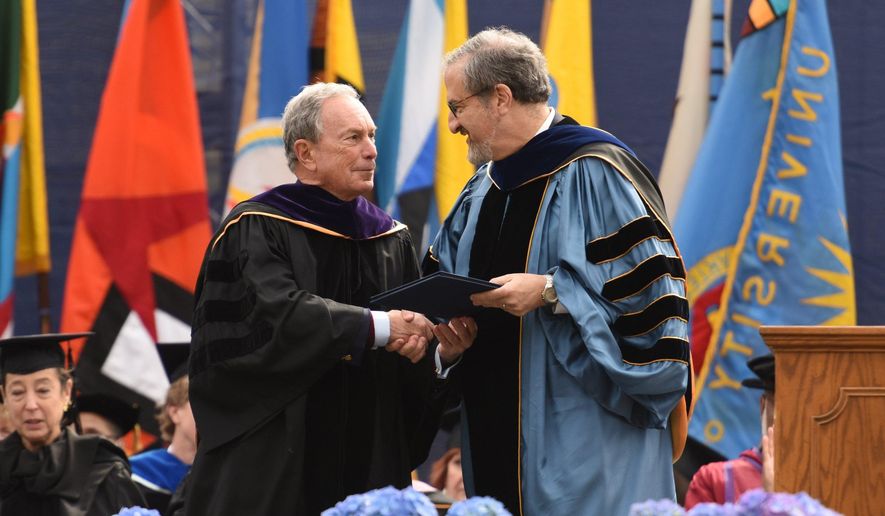 Former New York City Mayor Michael Bloomberg, left, accepts the honorary Doctor of Law degree from University of Michigan President Mark Schlissel, before giving the commencement address, at the University of Michigan&#39;s Class of 2016 graduation inside Michigan Stadium on Saturday, April 30, 2016. (Tanya Moutzalias /The Ann Arbor News - MLive.com Detroit via AP)