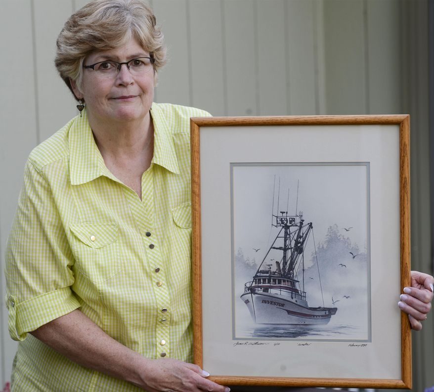 In this photo taken Wednesday, April 20, 2016, Laurie Hart poses with a painting of her brother Mark Coulthurst's fishing vessel the Investor painted by local artist James Williamson, at her home in Blaine, Wash. home. Almost 34 years ago, Mark Coulthurst, 28, the Investor’s skipper; his pregnant wife, Irene Coulthurst, also 28; their two children, Kimberly, 5, and John, 4; and Michael Stewart, 19, of Bellingham, a cousin of Mark Coulthurst, were killed aboard the Investor, a purse seiner found ablaze Sept. 7, 1982, near Craig, a fishing village in Southeast Alaska. (Philip A. Dwyer/The Bellingham Herald via AP) MANDATORY CREDIT