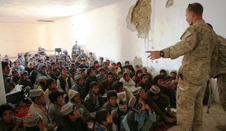 Marine Reserve Maj. Jason Brezler speaks with children attending school at the district center in Now Zad, Afghanistan, on Dec. 15, 2009. (1st Marine Division Public Affairs)