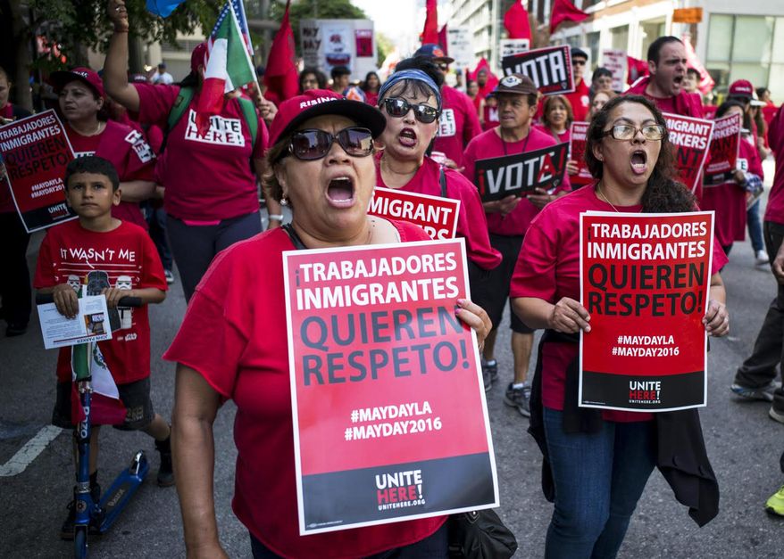 Hundreds of May Day marchers chanting slogans and carrying signs - these say 'Immigrant Workers Want Respect"- and at least one Donald Trump piñata, take to the streets of Los Angeles, calling for immigrant and worker rights and decrying what they see as hateful presidential campaign rhetoric, Sunday, May 1, 2016. It's one of several events in cities nationwide to call for better wages for workers, an end to deportations and support for an Obama administration plan to give work permits to immigrants in the country illegally whose children are American citizens.(David Crane/Los Angeles Daily News via AP) **FILE**