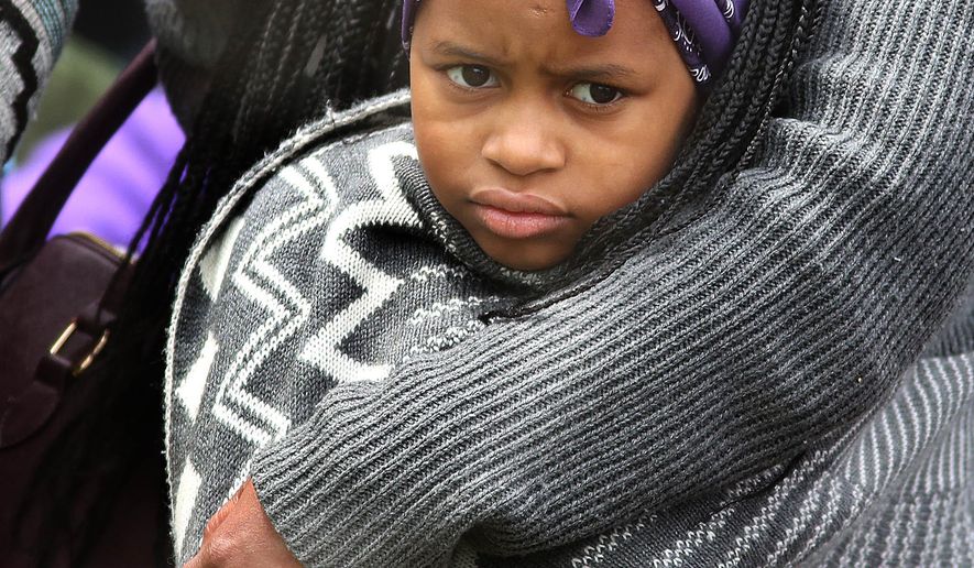 Aniyah Roland, 6, listens to Prince music in the protective arms of her aunt, Angel Jones during a Prince Block Party Saturday, April 30, 2016, at Sabathani Community Center in Minneapolis, Minn. (Jim Gehrz/Star Tribune via AP)