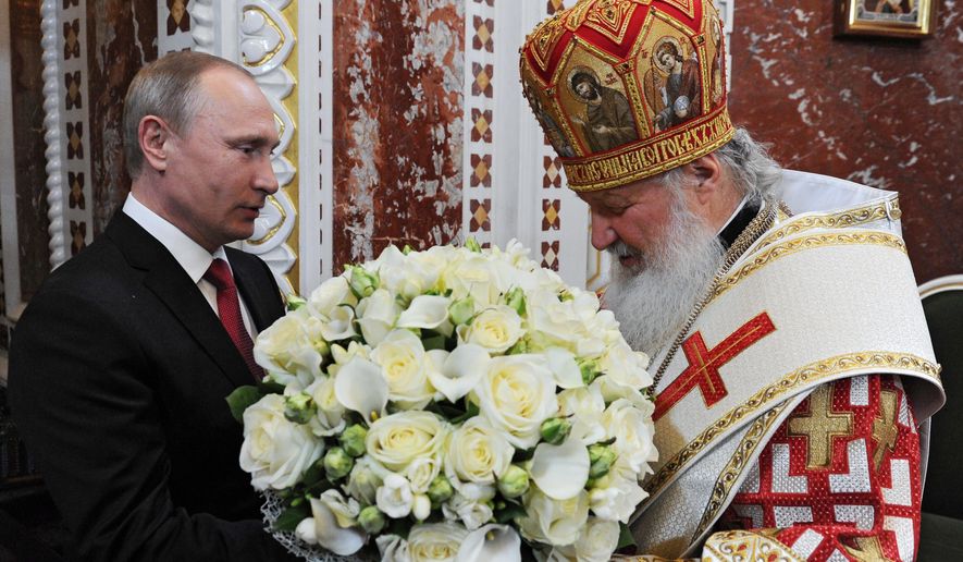 Russian President Vladimir Putin, left, congratulates Russia's Orthodox Church Patriarch Kirill with Easter prior to the Easter service in the Christ the Savior Cathedral in Moscow, Russia, early Sunday, May 1, 2016.(Mikhail Klimentyev/Sputnik, Kremlin Pool Photo via AP)