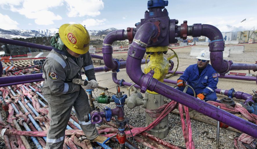 In this March 29, 2013, file photo, workers tend to a well head during a hydraulic fracturing operation outside Rifle, in western Colorado. The Colorado Supreme Court has struck down attempts by two cities to ban or delay fracking. The Monday, May 2, 2016, ruling is a victory for the oil and gas industry and for state officials who say only state government can regulate energy, not cities or counties. (AP Photo/Brennan Linsley, File)