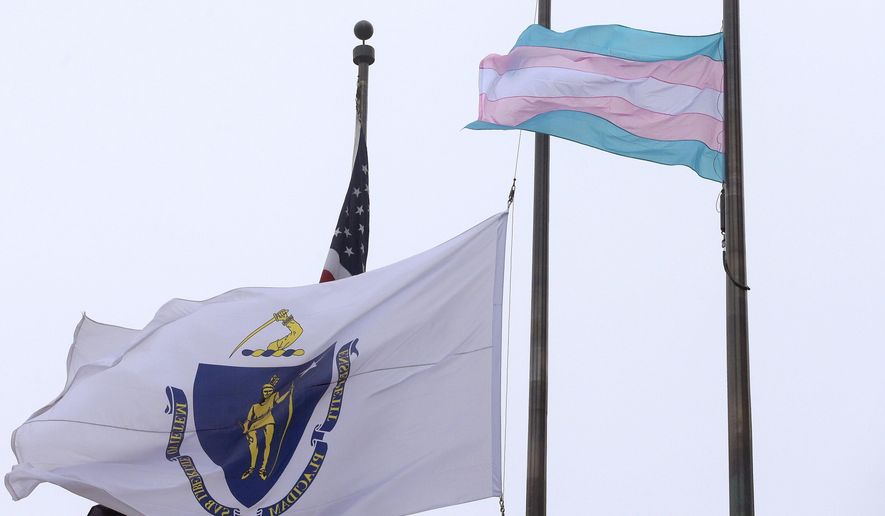 A flag representing the transgender community, right, flies next to the Massachusetts state flag, left, and an American flag, behind, in front of Boston City Hall, Monday, May 2, 2016, in Boston. Democratic Boston Mayor Marty Walsh, a supporter of transgender rights, said Monday the flag will continue to fly until everyone is equal under the law in Massachusetts. (AP Photo/Steven Senne)