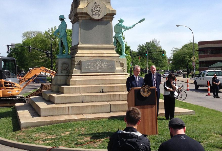 Louisville Mayor Greg Fischer speaks in front of the Confederate monument near the University of Louisville with university President James Ramsey, left, in Louisville, Ky., Friday, April 29, 2016. The Confederate monument capped with a statue of Jefferson Davis will be removed from a spot near the University of Louisville campus where it has stood since 1895. (AP Photo/Dylan Lovan)