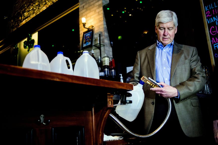 Gov. Rick Snyder fills up four one-gallon jugs with Flint water from a bar dispenser at Blackstone's Pub & Grill on Monday, May 2, 2016 in downtown Flint, Mich. Snyder says he is drinking Flint water while at work and home. Snyder has requested some face-to-face time with President Obama during his May 4 visit to Flint to get a firsthand look at the city's ongoing water crisis. (Jake May/The Flint Journal-MLive.com via AP)