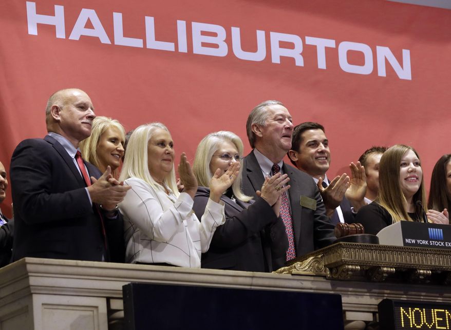 FILE - In a Nov. 18, 2014 file photo, Halliburton Chairman, President and CEO David Lesar, third from right, rings the New York Stock Exchange opening bell. Halliburton and Baker Hughes, two companies crucial to the business of U.S. energy exploration, have abandoned their planned $34 billion merger, the Justice Department said Sunday, May 1, 2016. The department filed suit April 6 to block the merger. (AP Photo/Richard Drew, File)