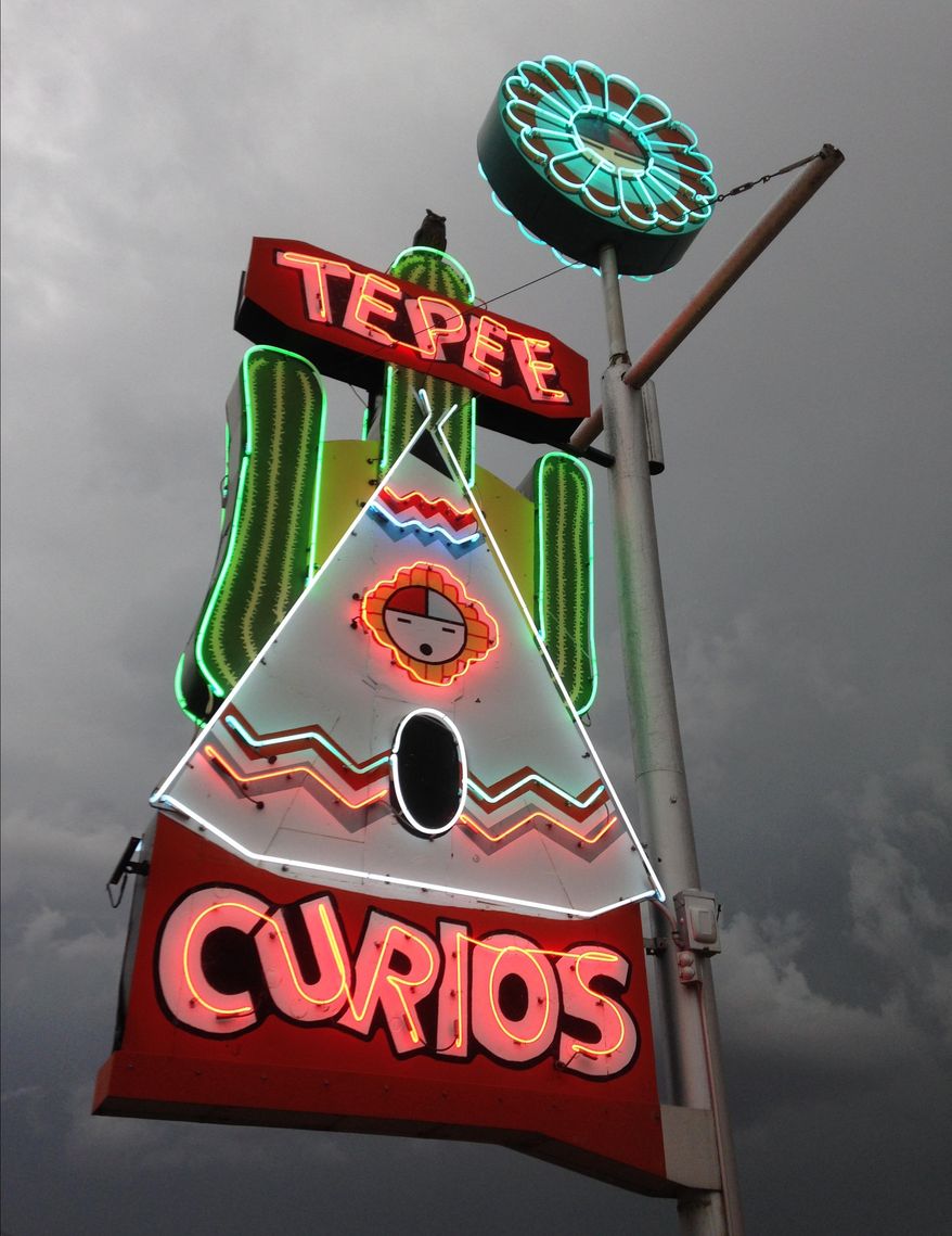 This June 7, 2014 image shows the Tepee Curios neon sign along historic Route 66 as a storm approaches in Tucumcari, N.M. The shop was originally a gas station that carried souvenirs and groceries. The American Indian Alaska Native Tourism Association has released a guidebook that details tribes and notable sites along the route. (AP photo/Susan Montoya Bryan)