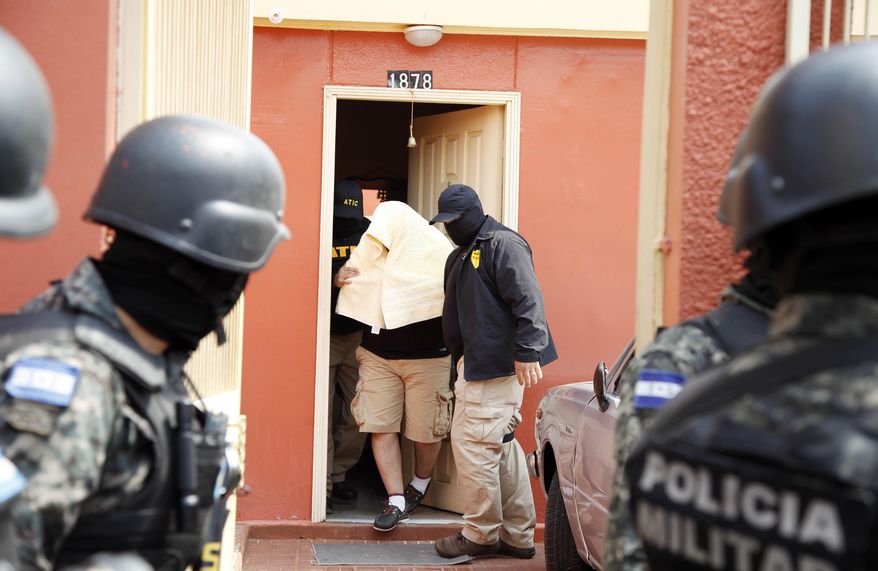 Police arrest a suspect in the murder of indigneous leader and environmentalist Berta Caceres in Tegucigalpa, Honduras, Monday, May 2, 2016. Honduran authorities have arrested four people in connection with Caceres' murder, including three who worked for a hydroelectric project she opposed. Caceres was shot dead by two unidentified men on March 3. (AP Photo/Fernando Antonio)