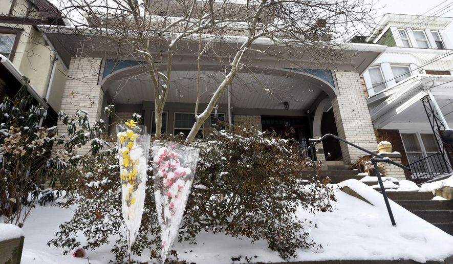 FILE - In this Feb. 10, 2014, file photo, flowers are left on the walkway to the house where sisters Susan Wolfe, a 44-year-old teacher's aide at a private school, and Sarah Wolfe, a 38-year-old psychiatrist at the University of Pittsburgh Medical Center's Western Psychiatric Institute and Clinic, were found dead of gunshot wounds Feb. 7, 2014, in the basement of the property in Pittsburgh. The Pittsburgh trial of a 45-year-old neighbor accused of killing the sisters, Allen Wade, began Monday, May 2, 2016. (AP Photo/Keith Srakocic, File)