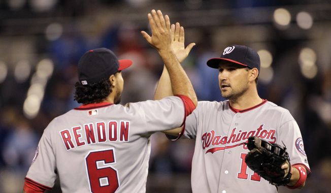 Washington Nationals Anthony Rendon (6) and Ryan Zimmerman (11) congratulate each other at the end of a baseball game against the Kansas City Royals at Kauffman Stadium in Kansas City, Mo., Monday, May 2, 2016. The Nationals beat the Royals 2-0. (AP Photo/Colin E. Braley)