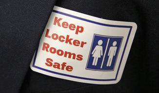 A sticker that reads &quot;Keep Locker Rooms Safe&quot; is worn by a person supporting a bill that would eliminate Washington&#39;s new rule allowing transgender people use gender-segregated bathrooms and locker rooms in public buildings consistent with their gender identity, at the Capitol in Olympia, Wash., on Jan. 27, 2016. In clashes over transgender students and which restrooms and locker rooms they should use, the U.S. Department of Education has warned public schools that a sex discrimination law makes it illegal to deny them access to the facilities of their choice. (Associated Press) **FILE**