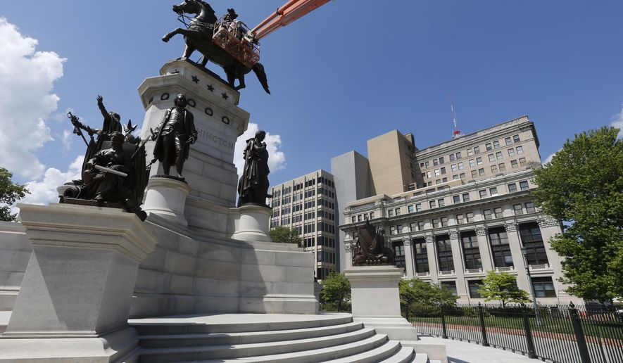 Workers make finishing touches on the restoration of the Capitol square statue of George Washington in front of the General Assembly building complex, which is on Preservation Virginia's 2016 list of the most endangered historic places in the state, in Richmond, Va., Monday, May 2, 2016. Virginia's most endangered historic places includes African-American cemeteries, an old plantation site plundered by treasure hunters as well as the General Assembly building. (AP Photo/Steve Helber)