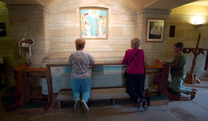 FILE - In this Oct. 2, 2000, file photo, worshippers kneel at the crypt of Saint Katharine Drexel a day after she was canonized at the Vatican as the second American-born saint, at her national shrine on the Sisters of the Blessed Sacrament's suburban Philadelphia estate in Bensalem, Pa. The Roman Catholic religious order, founded by Drexel in 1891, announced Tuesday, May 3, 2016, that it is selling the estate and plans to keep the shrine open through 2017, before moving the tomb to the Cathedral Basilica of Saints Peter & Paul in Philadelphia. The order will also sell 2,000 acres in Powhatan, Va., the site of two now-closed schools for black students. (AP Photo/Dan Loh, File)