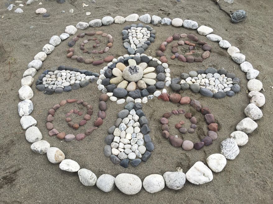 In a March 1, 2016 photo, one of Montana Banksy’s rock art designs is pictured on the banks of the Yellowstone River just upstream of Carter’s Bridge fishing access, with Banksy’s “calling card” in the center — a rock with an ornately painted black “M," near Livingston, Mont.