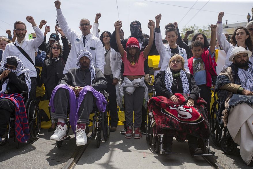 Hunger strikers from left, Ilyich Sato, Sellassie Blackwell, Maria Cristina Gutierrez and Edwin Lindo are wheeled during a protest march to City Hall from the Mission Police Station in San Francisco on Tuesday, May 3, 2016. Five San Francisco residents have been on a hunger strike for thirteen days calling for the resignation of police chief Greg Suhr to protest two recent shooting deaths of minorities by police and racist and homophobic texting scandals involving officers. (Jessica Christian/The San Francisco Examiner via AP) MANDATORY CREDIT