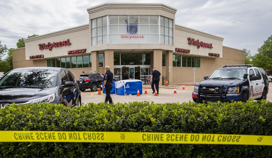 The body of a good samaritan lays under a blue tent after he was fatally shot outside a Walgreens on Monday, May 2, 2016, in Arlington, Texas, after he tried to stop a man who came to confront a woman who worked at the store. Arlington police say Anthony “T.J.” Antell Jr. saw Ricci Bradden shoot at the feet of his wife during an argument Monday outside of the Walgreens where she works, striking her once. Antell retrieved a handgun from his vehicle and confronted Bradden in an attempt to make a citizen’s arrest, but Bradden managed to slap it away and then fatally shot Antell, investigators say. (Ashley Landis/The Dallas Morning News via AP)
