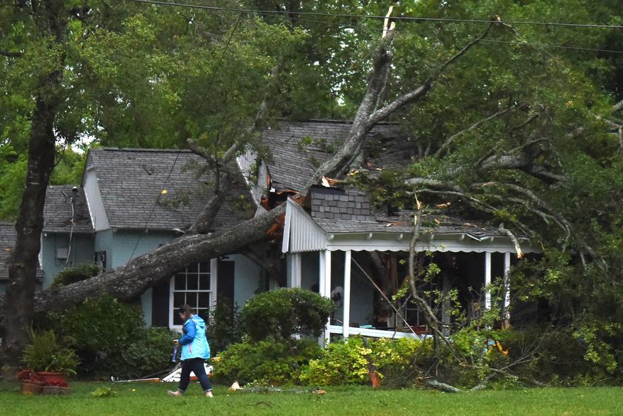 FILE - This April 29, 2016 file photo shows a house damaged by a fallen tree tree during storms in Lindale, Texas. More than 200 homes in East Texas were damaged or destroyed during last weekend's tornadoes and deadly flooding. Teams from the American Red Cross assisted with recovery in Anderson, Cherokee, Harrison, Lamar, Smith, Upshur and Wood counties on Tuesday May 3, 2016. (Sarah A. Miller/Tyler Morning Telegraph via AP File)