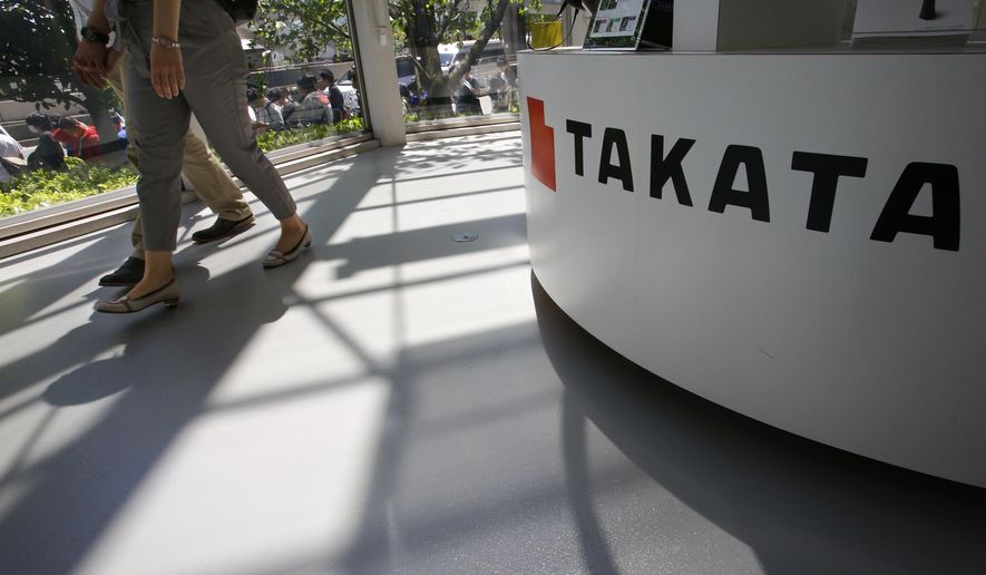 Visitors walk by child seats, manufactured and displayed by Takata Corp. at an automaker's showroom in Tokyo Wednesday, May 4, 2016. U.S. auto safety regulators are in talks with Takata Corp. to add tens of millions of air bag inflators to what already is the biggest auto recall in American history, three people briefed on the matter said Tuesday. (AP Photo/Shizuo Kambayashi)