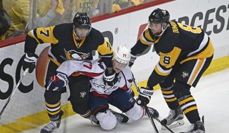 Washington Capitals T.J. Oshie (77) is sandwiched between Pittsburgh Penguins Matt Cullen (7) and Brian Dumoulin (8) during the first period of Game 4 in an NHL hockey Stanley Cup Eastern Conference semifinals in Pittsburgh, Wednesday, May 4, 2016. (AP Photo/Gene J. Puskar)