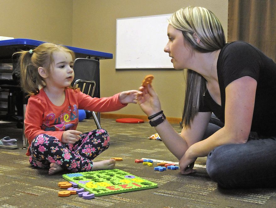 ADVANCE FOR USE SUNDAY, MAY 8 AND THEREAFTER - In this April 26, 2016 photo, MiKynna Cummings, left, works on numbers with occupational therapist Sara Joersz at the Red Door Pediatric Therapy center in Bismarck, N.D. MiKynna, who was diagnosed with autism when she was 15 months old, comes to Red Door Pediatric Therapy in Bismarck three times a week for speech and occupational therapy sessions. (Tom Stromme/The Bismarck Tribune via AP) MANDATORY CREDIT