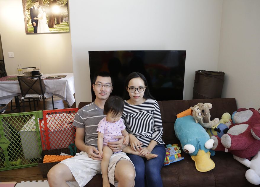 In this Wednesday, May 4, 2016, photo, Wei Wang poses with his wife and daughter in their Houston apartment. The Wangs and several other foreign investors had been banking on their investments in a biomedical research facility in northern Vermont to get green cards. (AP Photo/Pat Sullivan)