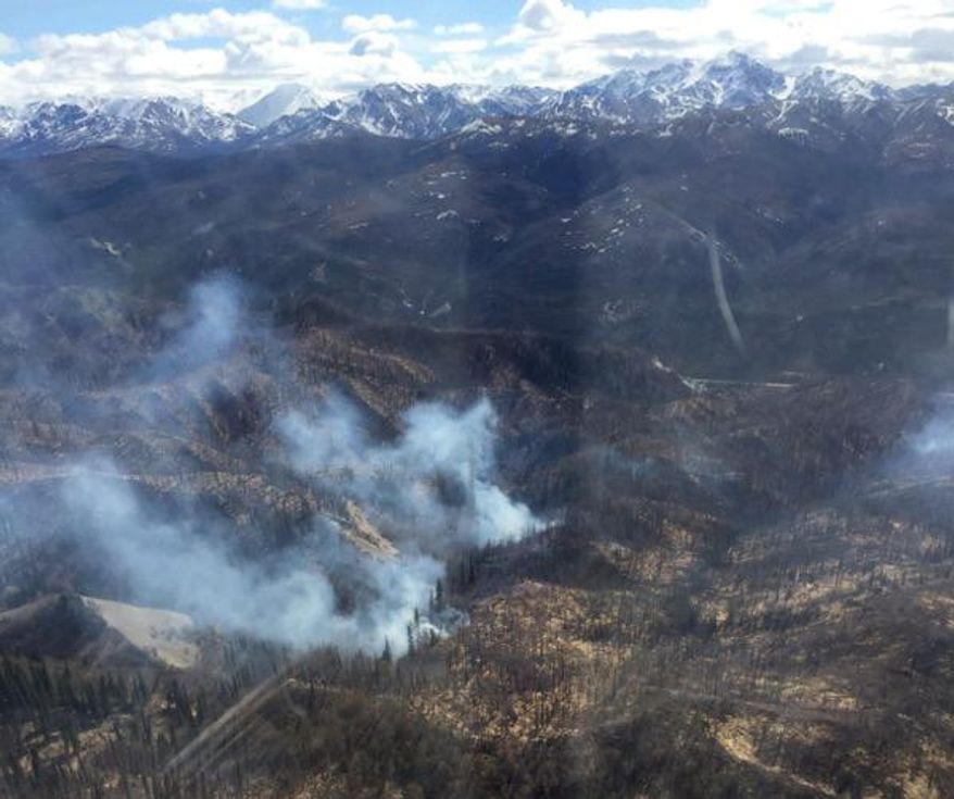 In this Wednesday, May 5, 2016 photo provided by the Alaska Division of Forestry, a wildfire believed to have started from underground coal seams burns near Healy, Alaska. Pockets of ignited coal smolder and burn in the area all year and last year ignited nine wildfires. The Alaska Division of Forestry used a helicopter to drop water on the fire to keep it contained within an old burn scar. (Cameron Winfrey/Alaska Division of Forestry via AP) MANDATORY CREDIT
