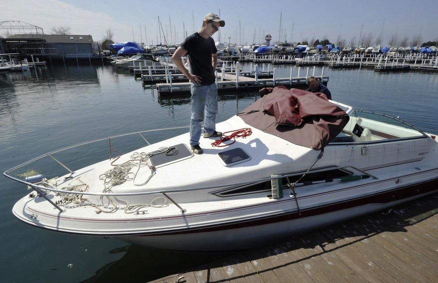 In this April 22, 2016 photo, Bay Harbor Marina service technician Neal Rudler helps get "One More Toy" in the water in Erie, Pa. (Greg Wohlford /Erie Times-News via AP) MANDATORY CREDIT; MAGS OUT